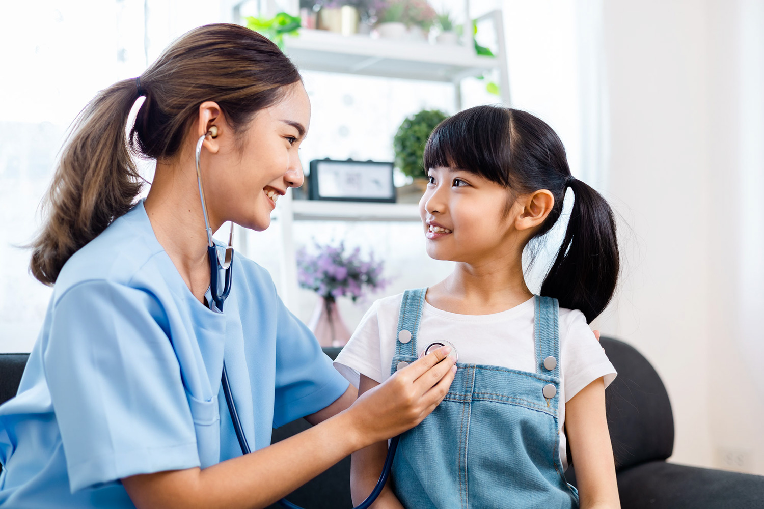 female nurse listening to a child's heartbeat