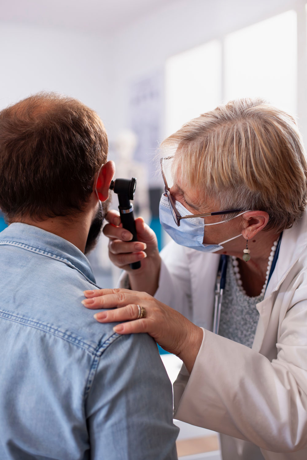 female ENT doctor checking a patients ears