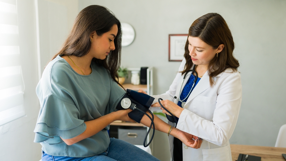 Doctor measuring young patients blood pressure