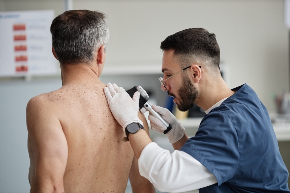 doctor checking patients back skin tags