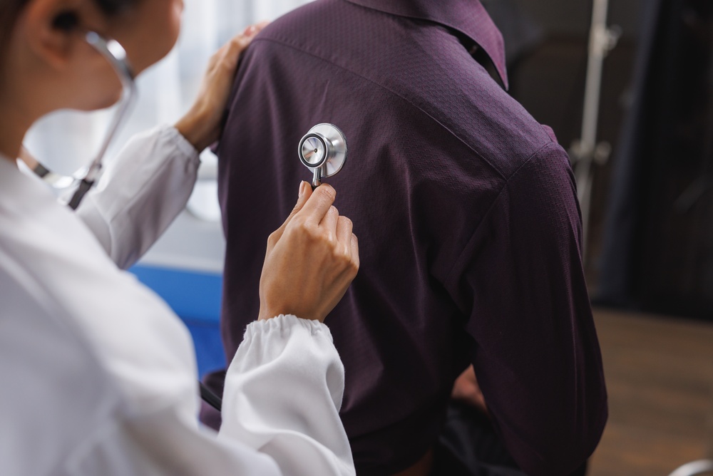 doctor checking patient's lungs with stethoscope