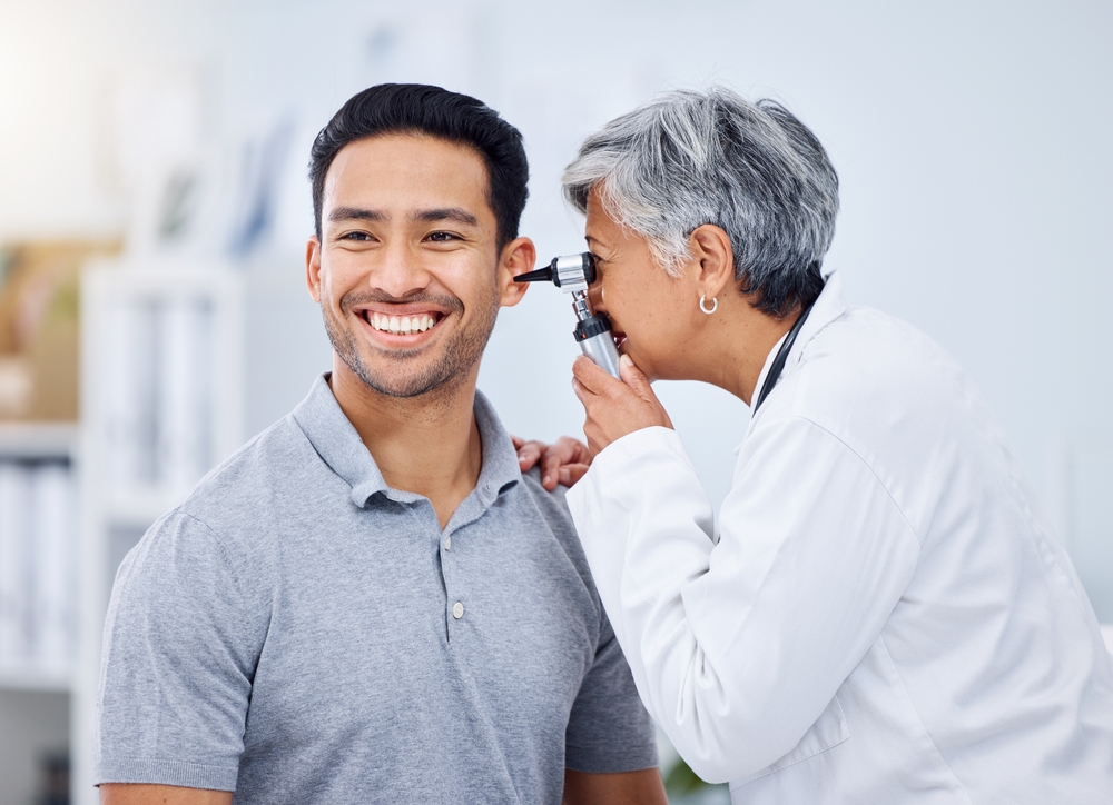 female doctor listening to elderly man's heartbeat