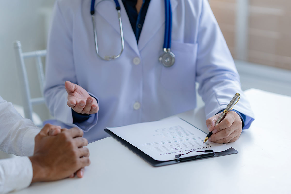 female doctor listening to elderly man's heartbeat