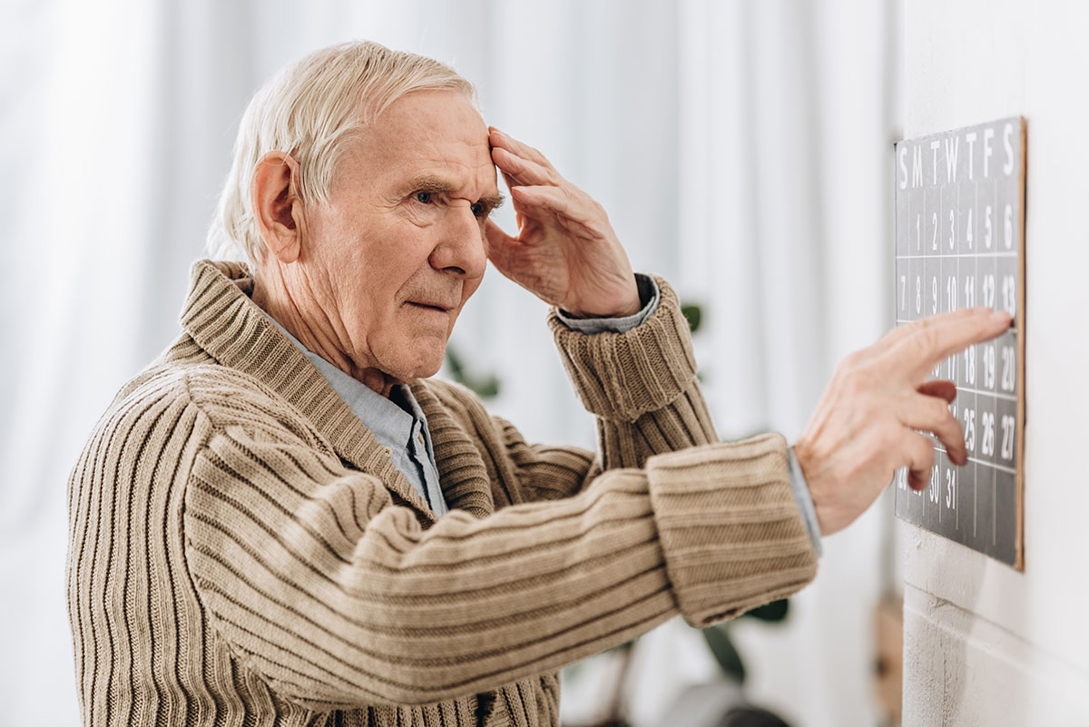 old man trying to read calendar