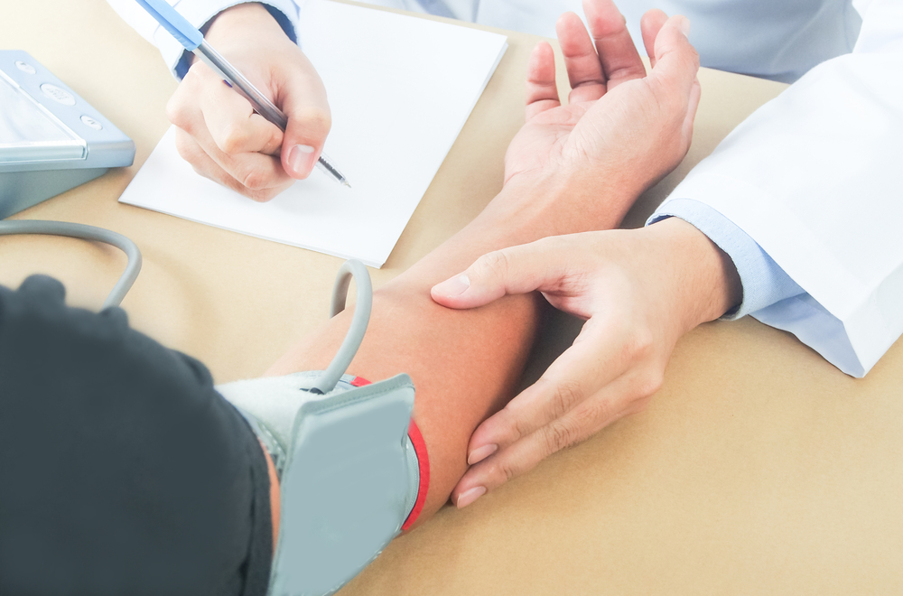 Doctor recording patient's blood pressure
