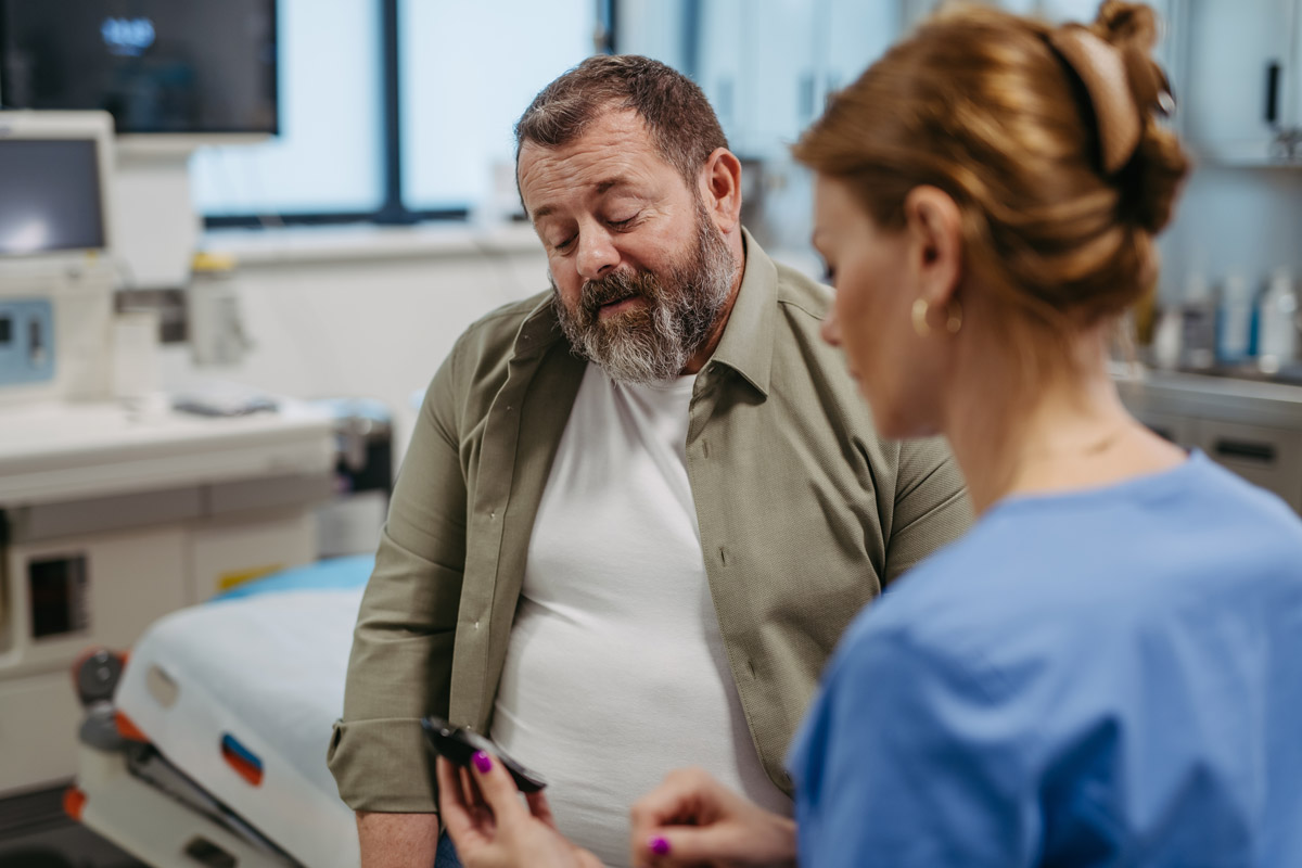 Female doctor showing a male patient his cholesterol levels at Townsen Physician Group in Houston