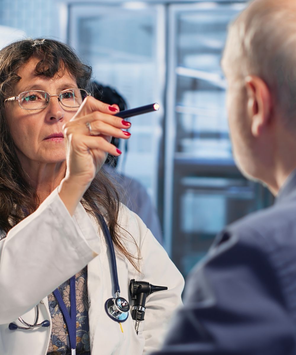 Female Doctor Checking Male Patient with Flashlight