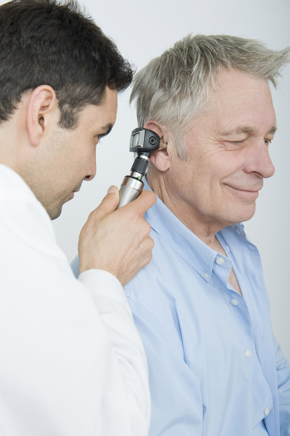 doctor checking patients ear with otoscope