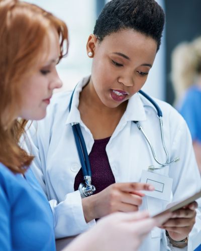 female doctor consulting female surgeon's assistant