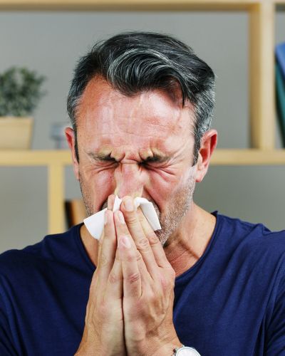Man Sneezing Into Tissue