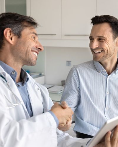 Male Doctor Raising Male Patient's Hand
