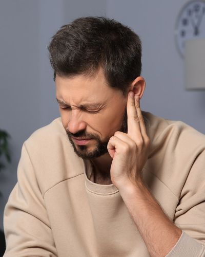 Young Man Touching Right Ear with Fingers