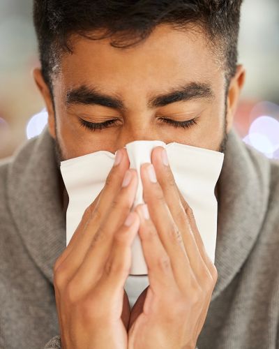 Man Sneezing Into Tissue Paper